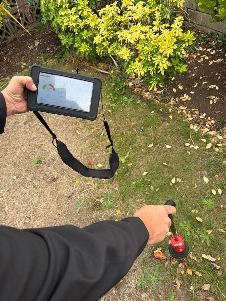 Handheld leak detector with a ground microphone used to pinpoint a hidden water leak under a floor or slab